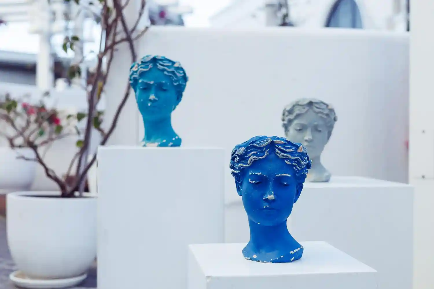 an image of three bust statues of a female in different colours—blue, light blue, and white, to show the various pillars and requirements of Australian AML Compliance