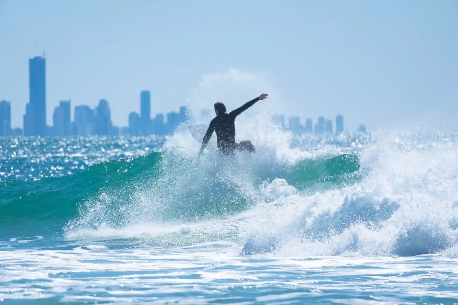 in image of a surfer against Perth's Skyline symbolizing the strength and dedication newly designated firms must have to fulfill their AML/CTF obligations
