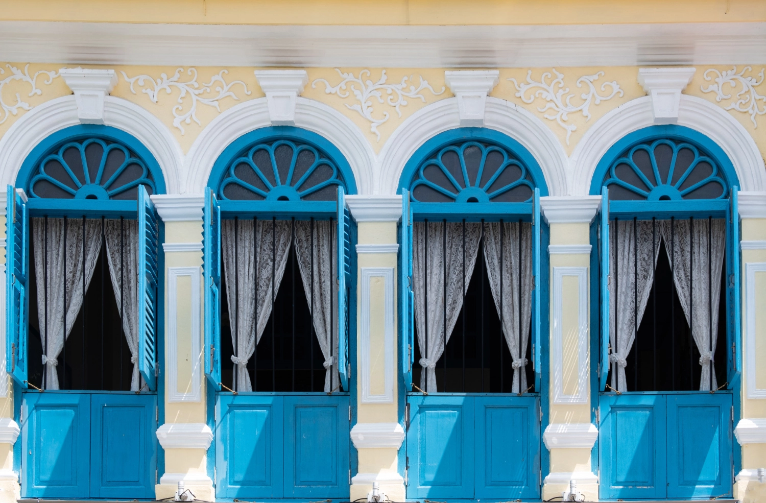 an image of four open blue windows with white lace curtains symbolising White Labelling vs Outsourcing