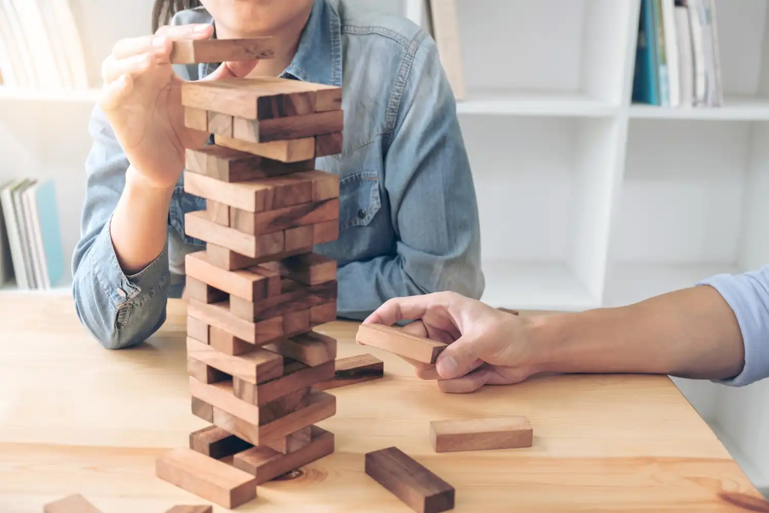 an image of people playing jengga, symbolising the importance of following the SMSF Compliance Checklist to ensure a healthy retirement fund