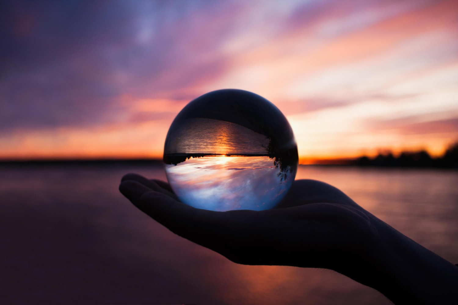 an image of a sunset over the beach seen through a crystal ball symbolising