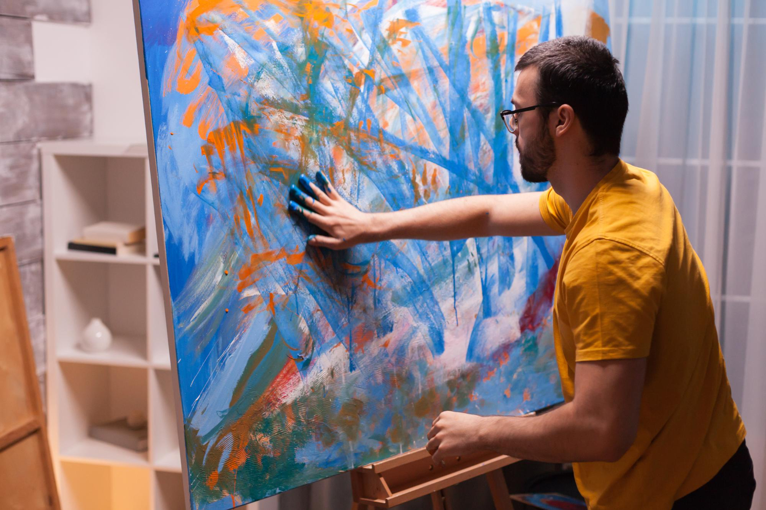 an image of a man painting in hues of blue and orange, symbolising the importance of following the SMSF Compliance Checklist