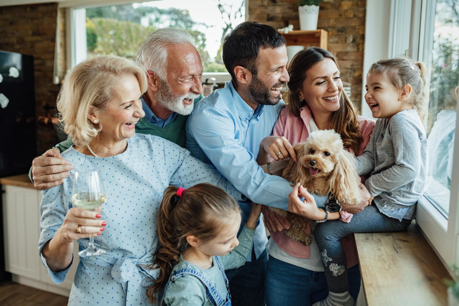an image of a happy family standing by the window, symbolising the peace of mind family businesses experience from understanding the difference between Family Constitution vs Shareholders Agreement