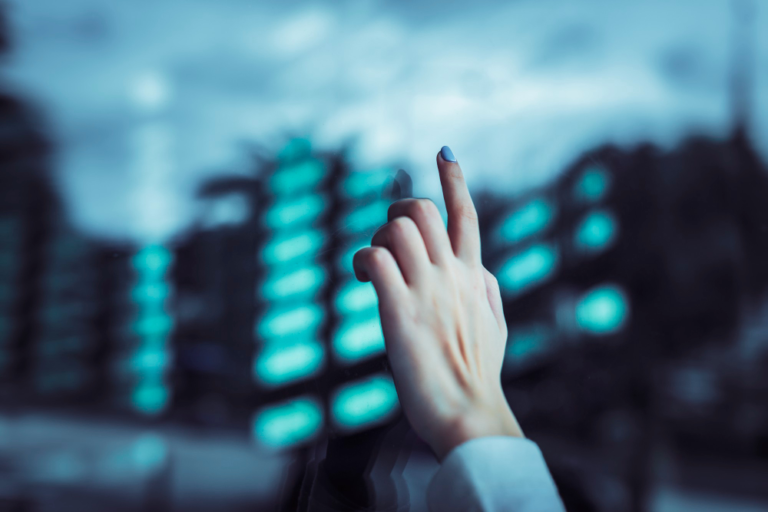 an image of a female cybersecurity expert reaching out a hand to point to through a glass window, symbolising the essential eight cybersecurity baseline controls for SMEs