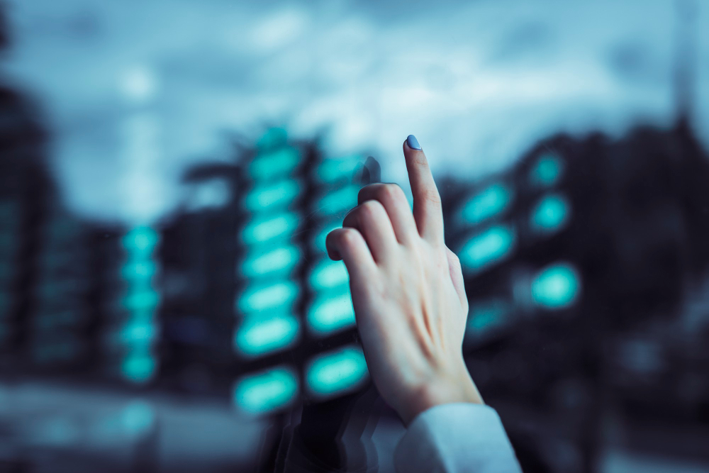 an image of a female cybersecurity expert reaching out a hand to point to through a glass window, symbolising the essential eight cybersecurity baseline controls for SMEs