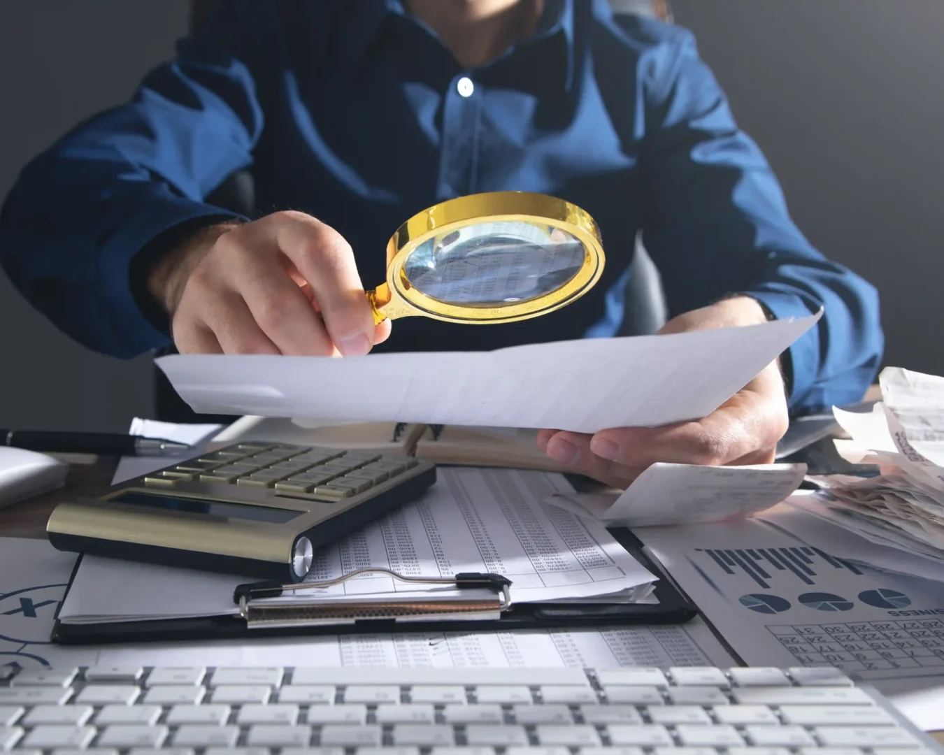 an image of a male specialist holding a magnifying glass to symbolise the regulatory compliance service that DBA Advisory provides as a Business Advisory & Outsourcing Firm