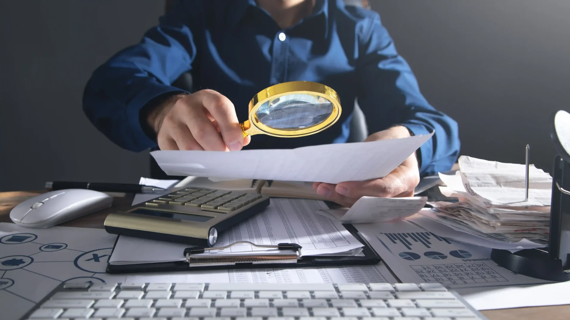 businessman-holding-magnifying-glass-with-documents-copy