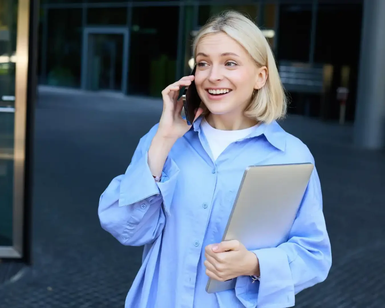 an image of a female business owner talking happily on the phone while carrying some documents symbolising the fast and easy turnaround services we provide. Contact DBA Advisory today!