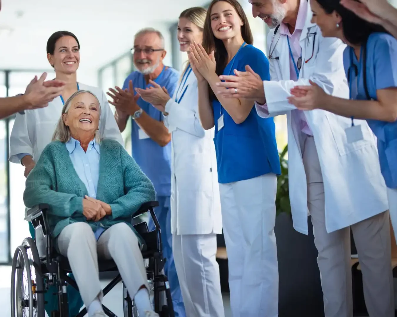 an image of a team of nurses and doctors, celebrating a patient who is leaving the hospital after a successful treatment symbolising the efficiency of healthcare delivery with the proper healthcare advisory