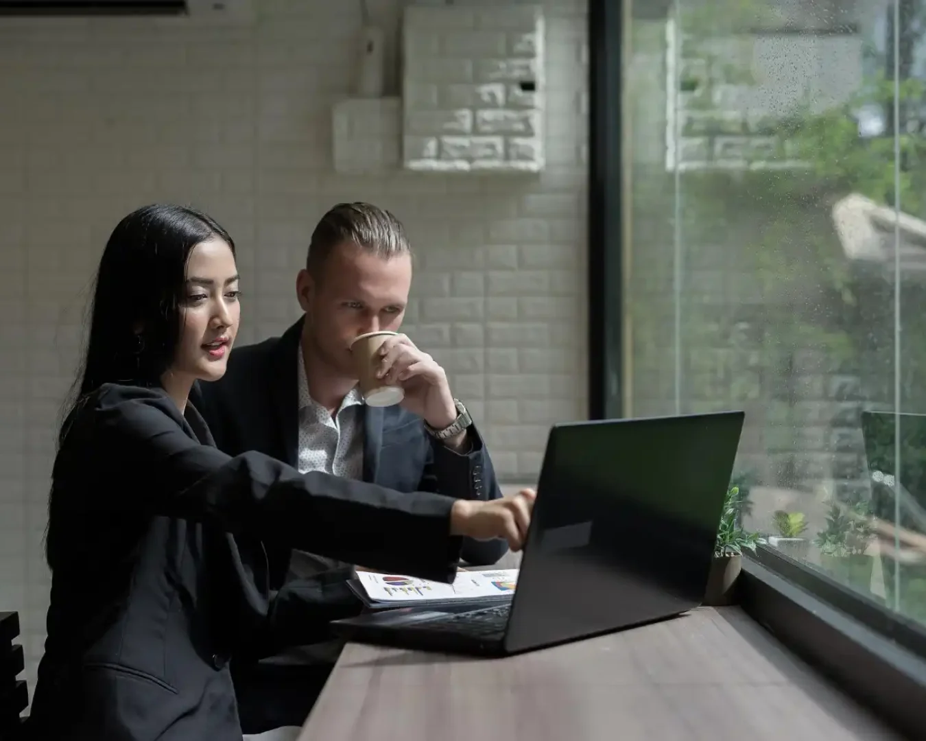 an image of a male and female business specialist discussing best possible strategy for their client using a laptop, symbolising the teamwork that we offer the various industries we serve worldwide
