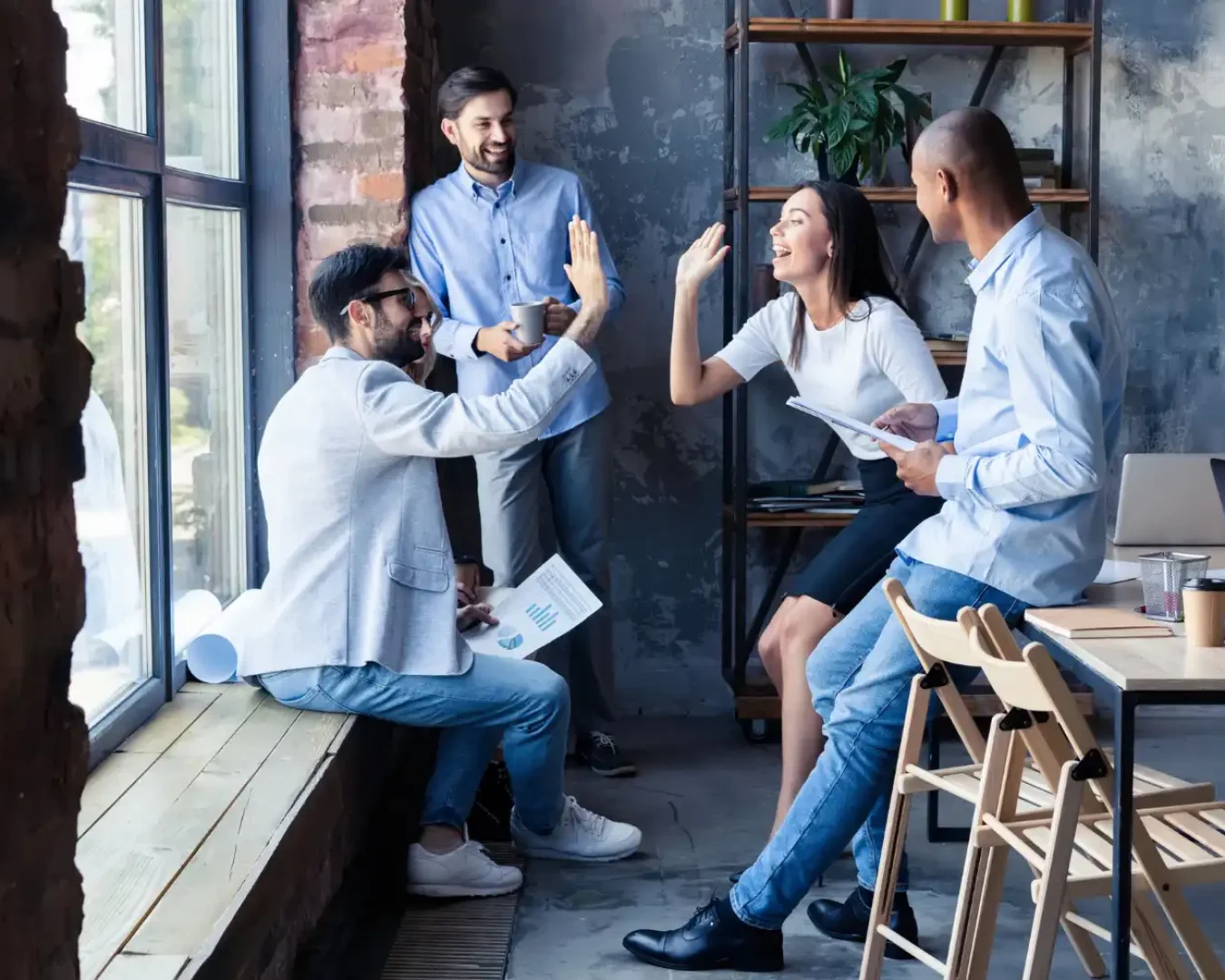 an image of a team of business professionals celebrating the success of their Business Advisory Services project over coffee