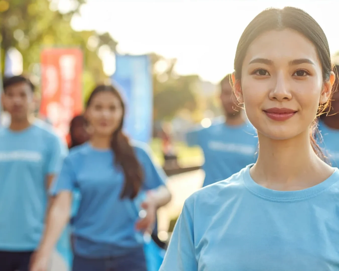 smiling-young-asian-woman-leading-group-volunteers-outdoors copy